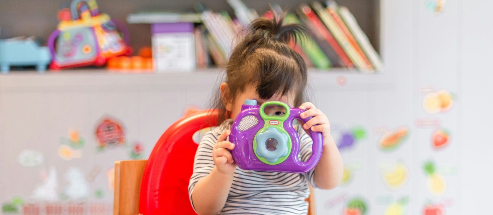 Kind spielt mit Spielzeugfotoapparat